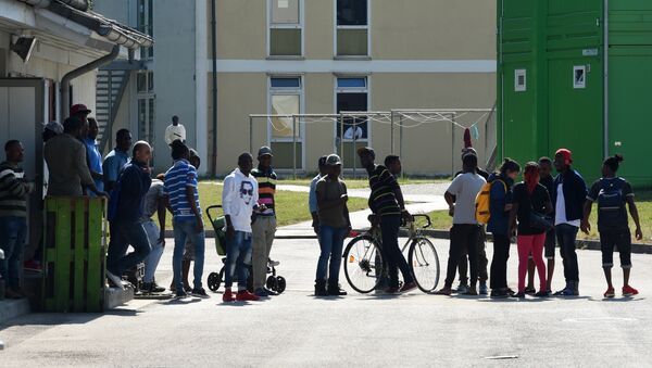 Residents of the Bavarian transit center (Bayerisches Transitzentrum) for asylum seekers stand in front of an office building, in Manching, near Ingolstadt, southern Germany, on May 15, 2018 - Sputnik International