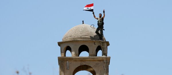 A Syrian army soldier gestures as he holds a Syrian flag in Quneitra, Syria July 27, 2018 A Syrian army soldier gestures as he holds a Syrian flag in Quneitra, Syria July 27, 2018 - Sputnik International