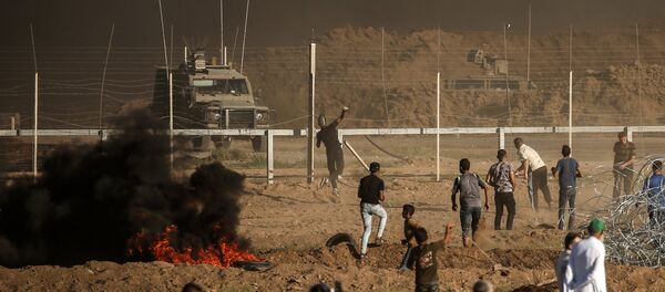 Palestinian protesters throw stones towards Israeli forces during a demonstration along the border between Israel and the Gaza strip, east of Gaza city on July 27, 2018 Palestinian protesters throw stones towards Israeli forces during a demonstration along the border between Israel and the Gaza strip, east of Gaza city on July 27, 2018 - Sputnik International
