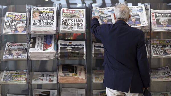 A man picks up a newspaper reporting the development following Britain's general election at a shop in Westminster in London, Saturday June 10, 2017 - Sputnik International