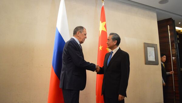 Russian Foreign Minister Sergei Lavrov Shake Hands with his Chinese counterpart Wang Yi - Sputnik International