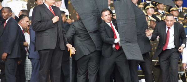 In this photo released by China's Xinhua News Agency, security personnel surround Venezuela's President Nicolas Maduro during an incident as he was giving a speech in Caracas, Venezuela, Saturday, Aug. 4, 2018 In this photo released by China's Xinhua News Agency, security personnel surround Venezuela's President Nicolas Maduro during an incident as he was giving a speech in Caracas, Venezuela, Saturday, Aug. 4, 2018 - Sputnik International