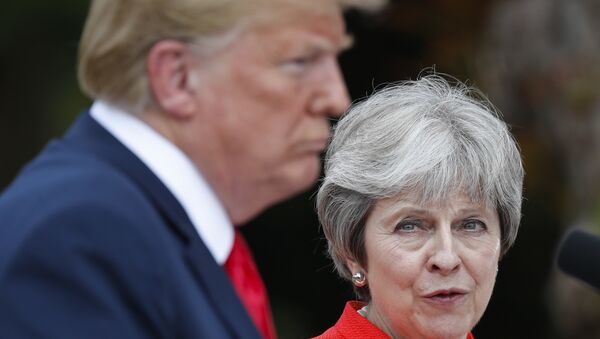 British Prime Minister Theresa May, right, looks over to President Donald Trump, left, during their joint news conference at Chequers, in Buckinghamshire, England, Friday, July 13, 2018 - Sputnik International