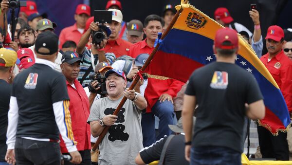Argentina's former soccer star Diego Armando Maradona waves a Venezuelan flag during the closing campaign rally of President Nicolas Maduro in Caracas, Venezuela, Thursday, May 17, 2018. Maduro is seeking a new six-year mandate and despite crippling hyperinflation and widespread shortages of food and medicine, he is widely expected to win it in next May 20 election, that opponents have denounced as a fraud and have been condemned by much of the international community - Sputnik International