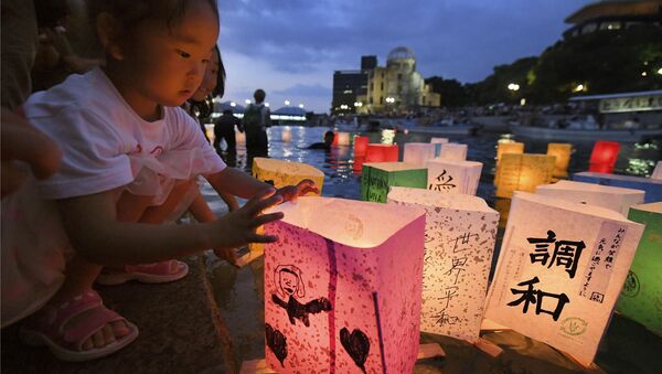 A girl releases paper lanterns on the Motoyasu river facing the gutted Atomic Bomb Dome in remembrance of atomic bomb victims on the 73rd anniversary of the bombing of Hiroshima, western Japan, August 6, 2018 - Sputnik International