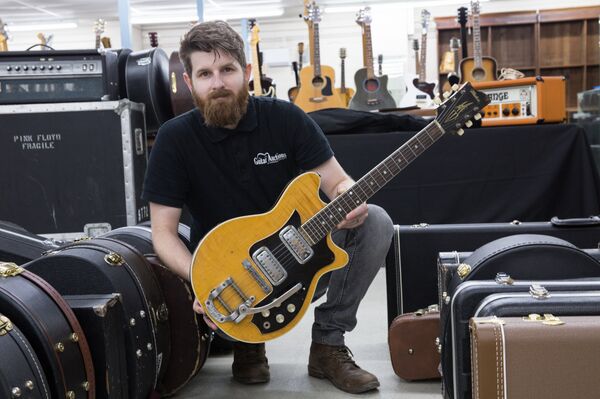 Gardiner Houlgate expert and auctioneer Luke Hobbs holds the Maton  - Sputnik International