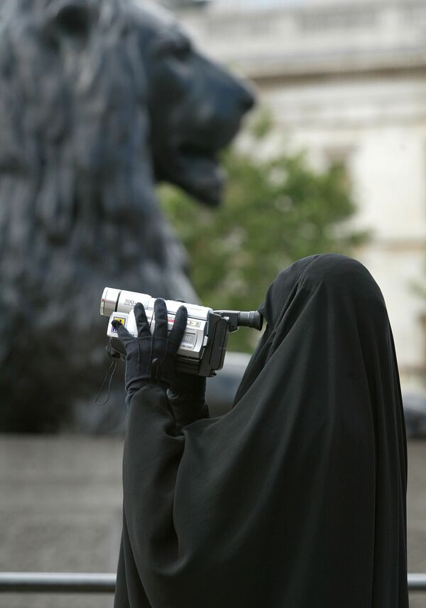 A woman in traditional Muslim gowns videofilms her family under the watchful eyes of the lions guarding the Nelson column at Trafalgar square in London, 12 August 2002. A woman in traditional Muslim gowns videofilms her family under the watchful eyes of the lions guarding the Nelson column at Trafalgar square in London, 12 August 2002. - Sputnik International