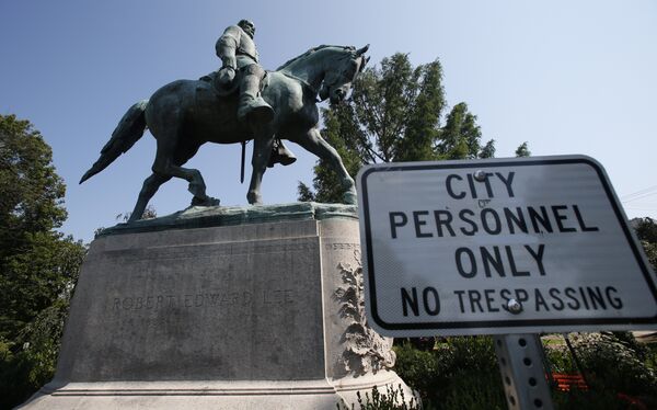 In this Monday, Aug. 6, 2018 photo, a No Trespassing sign is displayed in front of a statue of Robert E. Lee in Charlottesville, Va., at the park that was the focus of the Unite the Right rally. Pressure to take down America’s monuments honoring slain Confederate soldiers and the generals who led them didn’t start with Charlottesville. But the deadly violence that rocked the Virginia college town a year ago gave the issue an explosive momentum. In this Monday, Aug. 6, 2018 photo, a No Trespassing sign is displayed in front of a statue of Robert E. Lee in Charlottesville, Va., at the park that was the focus of the Unite the Right rally. Pressure to take down America’s monuments honoring slain Confederate soldiers and the generals who led them didn’t start with Charlottesville. But the deadly violence that rocked the Virginia college town a year ago gave the issue an explosive momentum. - Sputnik International