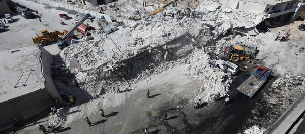 Destroyed buildings are seen on August 12, 2018 following an explosion at an arms depot in a residential area in Syria's northern Idlib province city of Sarmada in which 12 people were reportedly killed. Destroyed buildings are seen on August 12, 2018 following an explosion at an arms depot in a residential area in Syria's northern Idlib province city of Sarmada in which 12 people were reportedly killed. - Sputnik International