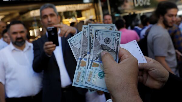 A businessman holding U.S. dollars poses for his friend in front of a currency exchange office in response to the call of Turkish President Tayyip Erdogan on Turks to sell their dollar and euro savings to support the lira, in Ankara, Turkey August 14, 2018 - Sputnik International