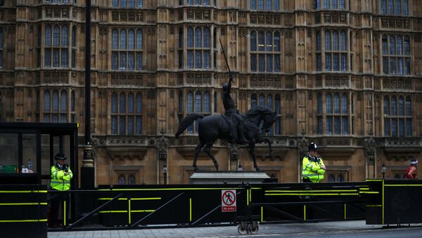 Police officers stand at the vehicle barrier to the Houses of Parliament where a car crashed after knocking down cyclists and pedestrians yesterday in Westminster, London, Britain, August 15, 2018 - Sputnik International
