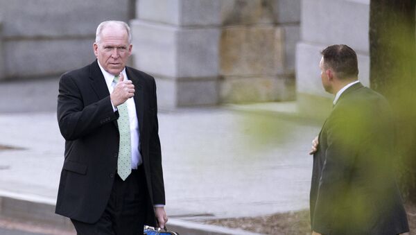An aide awaits CIA Director John Brennan, left, as he leaves the White House in Washington - Sputnik International