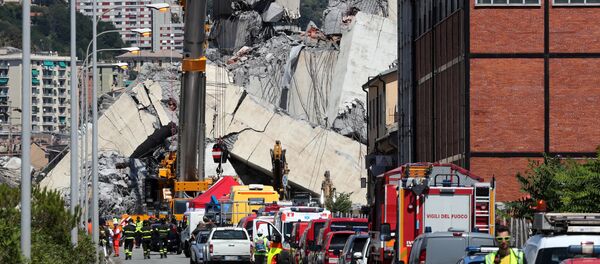 Firefighters and rescue workers stand at the site of a collapsed Morandi Bridge in the port city of Genoa, Italy August 15, 2018 - Sputnik International