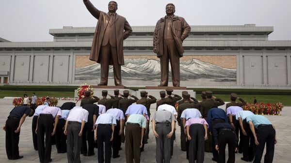 Поклонение перед бронзовыми статуями бывших лидеров КНДР Ким Ир Сена и Ким Чен Ира в ознаменование годовщины окончания японского колониального господства - Sputnik International