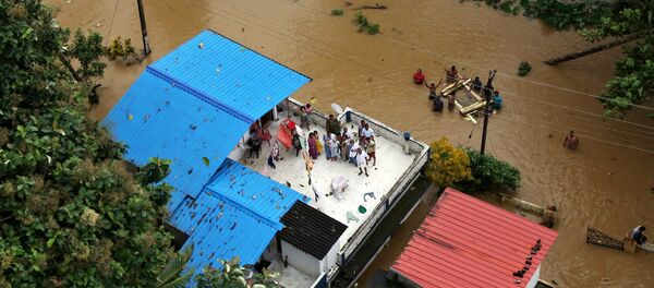 People wait for aid on the roof of their house at a flooded area in the southern state of Kerala, India, August 17, 2018 People wait for aid on the roof of their house at a flooded area in the southern state of Kerala, India, August 17, 2018 - Sputnik International