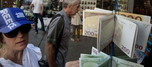 A woman wearing a hat in the colors of Greece's national flag, looks at wallets designed as Euro banknotes on display, outside a kiosk in central Athens - Sputnik International