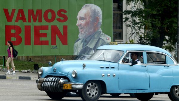 A taxi passes a sign with Cuban President Fidel Castro - Sputnik International