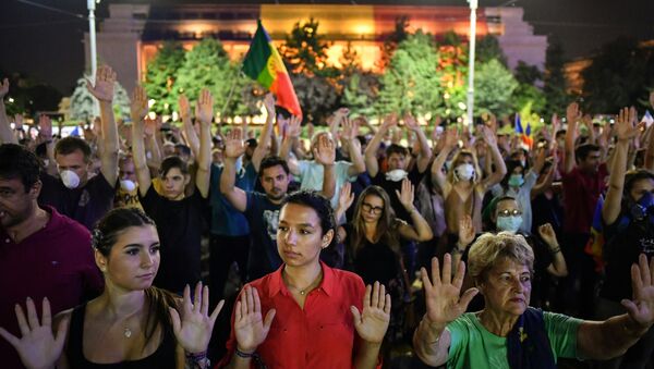 People raise their hands during a protest in front of the Romanian Government headquarters in Bucharest on August 17, 2018 - Sputnik International