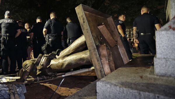 Police stand guard after the confederate statue known as Silent Sam was toppled by protesters on campus at the University of North Carolina in Chapel Hill, N.C., Monday, Aug. 20, 2018 - Sputnik International