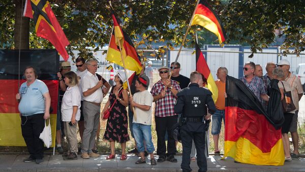 This picture taken on August 16, 2018 in Dresden, eastern Germany, shows anti-Islam Pegida movement supporters demonstrating on the occasion of German Chancellor's visit at the Saxon state parliament - Sputnik International