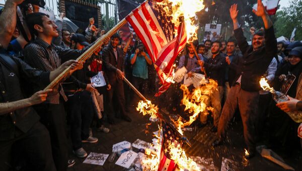 Iranians burn US flags during an anti-US demonstration outside the former US embassy headquarters in the capital Tehran on May 9, 2018. - Sputnik International