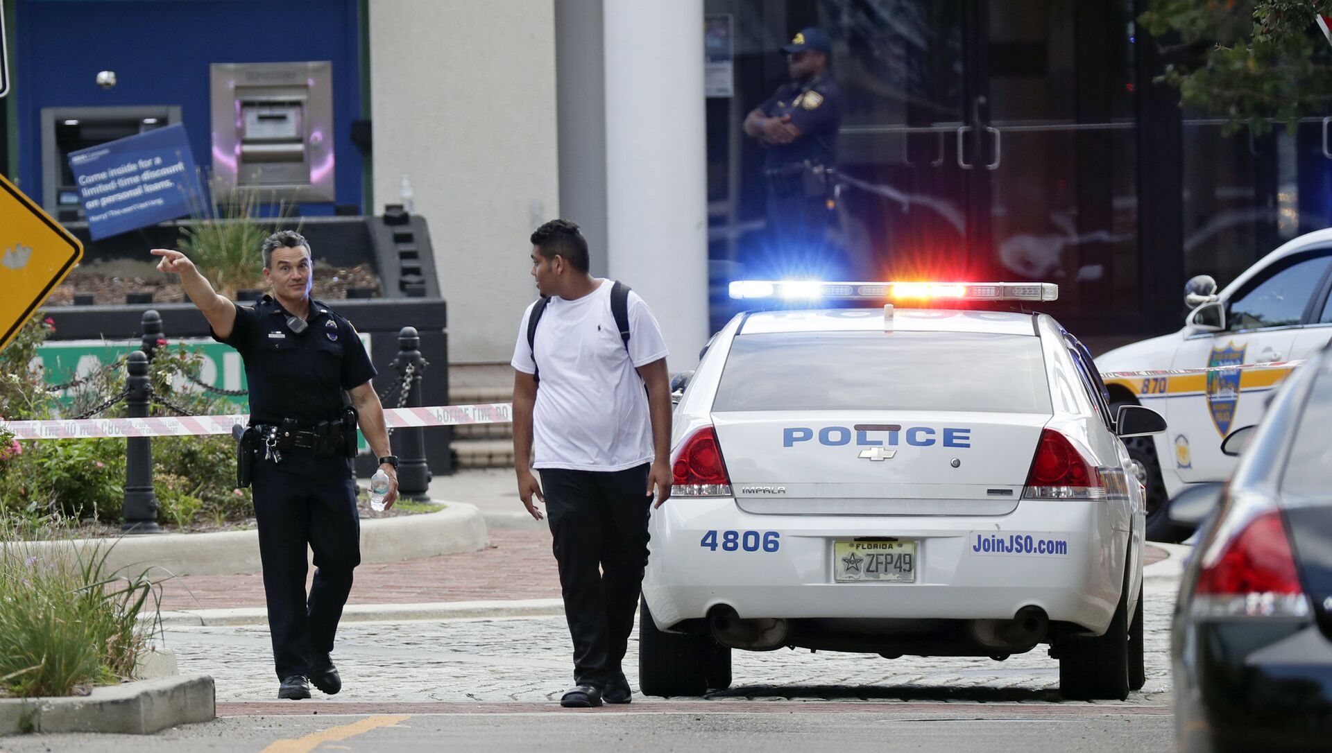 A police officer directs a pedestrian away from a blocked-off area near the scene of a mass shooting at Jacksonville Landing in Jacksonville, Fla., Sunday, Aug. 26, 2018. - Sputnik International, 1920, 08.05.2021