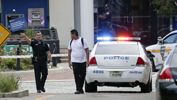 A police officer directs a pedestrian away from a blocked-off area near the scene of a mass shooting at Jacksonville Landing in Jacksonville, Fla., Sunday, Aug. 26, 2018. - Sputnik International