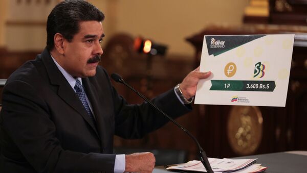 Venezuela's President Nicolas Maduro holds a sign showing the value of a Petro compared with the new Venezuelan currency Bolivar Soberano (Sovereign Bolivar), as he speaks during a meeting with ministers at Miraflores Palace in Caracas, Venezuela August 17, 2018. - Sputnik International