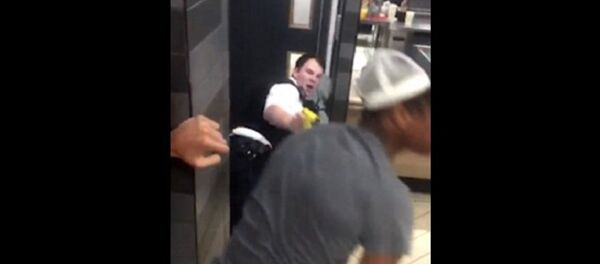 After a man in white is pictured kicking one of the police officers, another onlooker (pictured in grey with pink balloon in his mouth) approaches the two PCs - Sputnik International