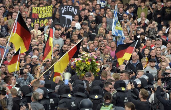 Protesters carry a wreath as they gather for a far-right protest in Chemnitz, Germany, Monday, Aug. 27, 2018 after a man has died and two others were injured in an altercation between several people of various nationalities in the eastern German city of Chemnitz on Sunday Protesters carry a wreath as they gather for a far-right protest in Chemnitz, Germany, Monday, Aug. 27, 2018 after a man has died and two others were injured in an altercation between several people of various nationalities in the eastern German city of Chemnitz on Sunday - Sputnik International
