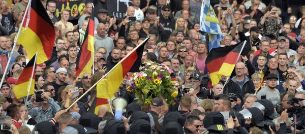 Protesters carry a wreath as they gather for a far-right protest in Chemnitz, Germany, Monday, Aug. 27, 2018 after a man has died and two others were injured in an altercation between several people of various nationalities in the eastern German city of Chemnitz on Sunday Protesters carry a wreath as they gather for a far-right protest in Chemnitz, Germany, Monday, Aug. 27, 2018 after a man has died and two others were injured in an altercation between several people of various nationalities in the eastern German city of Chemnitz on Sunday - Sputnik International