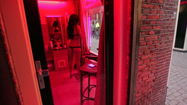 A prostitute waits for clients behind her window in the red light district of Amsterdam on December 8, 2008. - Sputnik International