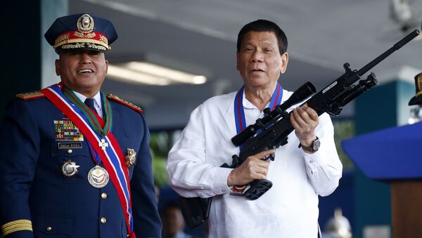 April 19, 2018 file photo, Philippine President Rodrigo Duterte, right, jokes to photographers as he holds an Israeli-made Galil rifle which was presented to him by former Philippine National Police Chief Director General Ronald Bato Dela Rosa at the turnover-of-command ceremony at the Camp Crame in Quezon city northeast of Manila - Sputnik International