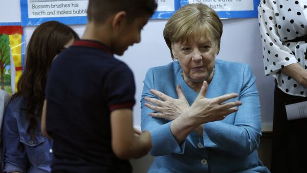 German Chancellor Angela Merkel, right, sits inside a classroom, as she speaks with Lebanese and Syrian displaced students where they studying together, during her visit to a Lebanese public school, in Beirut, Lebanon, Friday, June 22, 2018. Merkel is visiting Jordan and Lebanon, both neighbors of war-torn Syria, amid an escalating domestic row over migration - Sputnik International