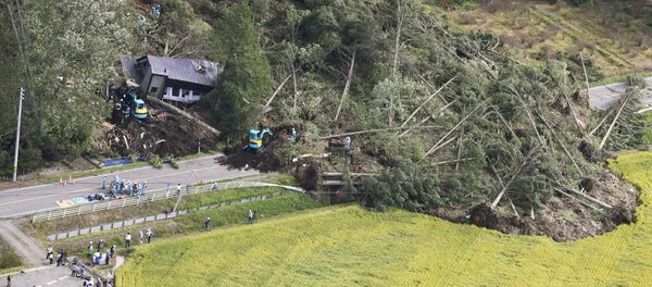 Police officers and rescue workers search for survivors from a building damaged by a landslide caused by a powerful earthquake in Atsuma town in Japan's northern island of Hokkaido, Japan, in this photo taken by Kyodo September 6, 2018. - Sputnik International