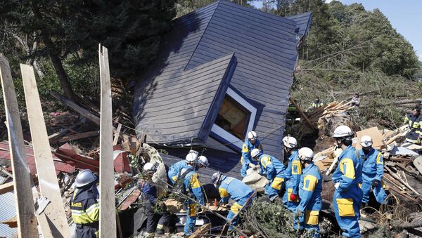 Rescue workers search for survivors from a house damaged by a landslide caused by an earthquake in Atsuma town, Hokkaido, Japan, in this photo taken by Kyodo September 6, 2018 - Sputnik International