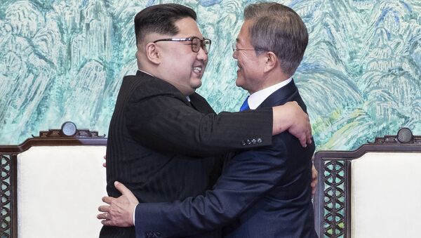 North Korean leader Kim Jong Un, left, and South Korean President Moon Jae-in embrace each other after signing on a joint statement at the border village of Panmunjom in the Demilitarized Zone, South Korea, Friday, April 27, 2018. - Sputnik International