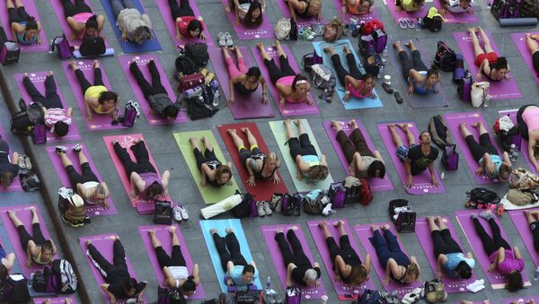 People practice yoga in New York's Times Square, Friday, June 21, 2013. Yoga enthusiast marked the longest day of the year with five free Mind Over Madness yoga classes in Times Square. - Sputnik International