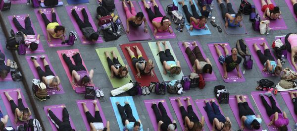 People practice yoga in New York's Times Square, Friday, June 21, 2013. Yoga enthusiast marked the longest day of the year with five free Mind Over Madness yoga classes in Times Square. - Sputnik International