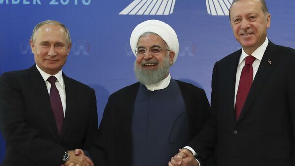 Iran's President Hassan Rouhani, centre, flanked by Russia's President Vladimir Putin, left, and Turkey's President Recep Tayyip Erdogan, pose for photographs in Tehran, Iran, ahead of their summit to discuss Syria, Friday, Sept. 7, 2018 - Sputnik International