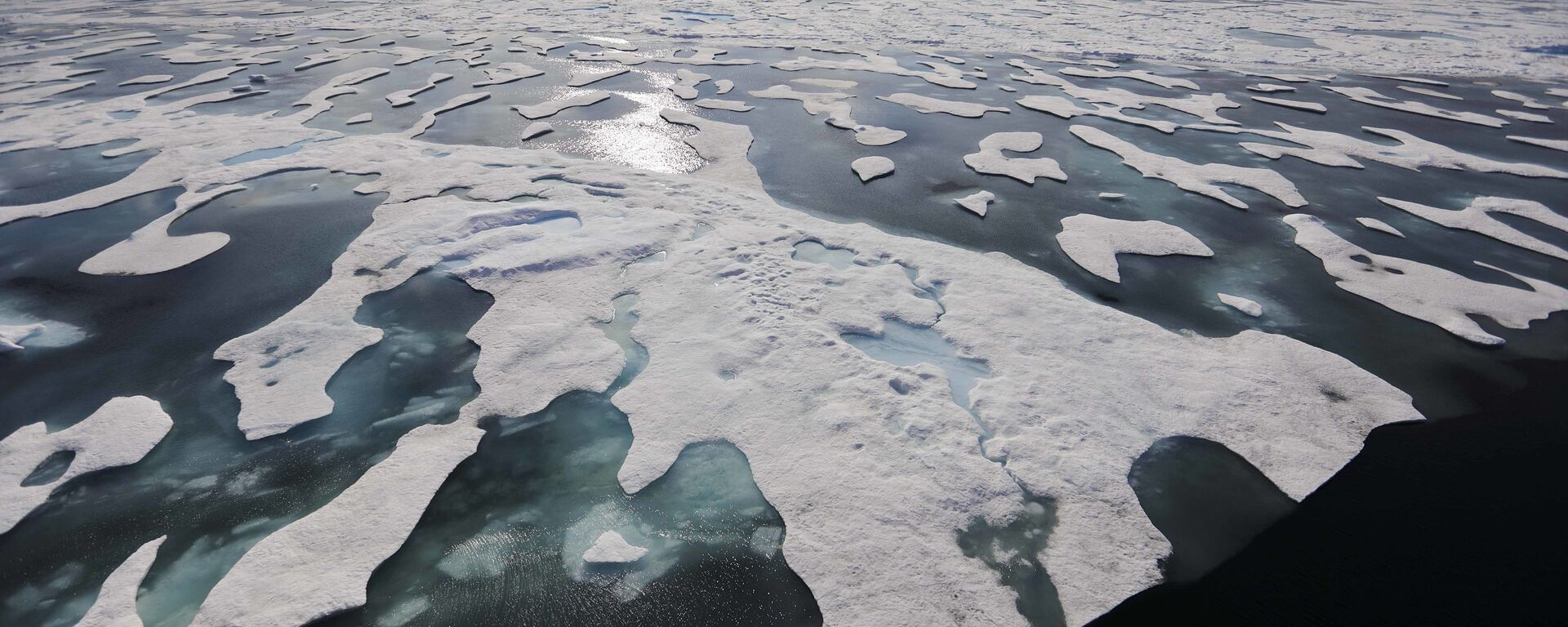 Sea ice melts on the Franklin Strait along the Northwest Passage in the Canadian Arctic Archipelago, Saturday, July 22, 2017. Because of climate change, more sea ice is being lost each summer than is being replenished in winters. Less sea ice coverage also means that less sunlight will be reflected off the surface of the ocean in a process known as the albedo effect. The oceans will absorb more heat, further fueling global warming - Sputnik International, 1920, 20.07.2022