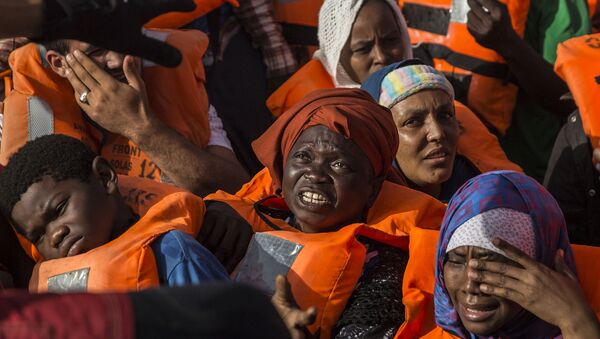 Migrants aboard a rubber dinghy off the Libyan coast receive aid from rescuers aboard the Open Arms aid boat, of Proactiva Open Arms Spanish NGO, Saturday, June 30, 2018. - Sputnik International