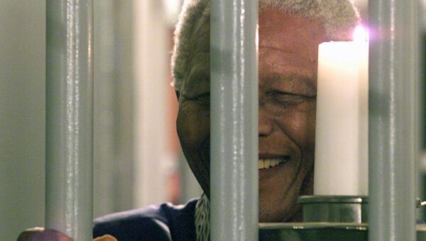 Former South African President Nelson Mandela holds a symbolic millennium candle 31 December 1999 in his cell at the prison of Robben Island where he was imprisoned for 27 years during the apartheid time. - Sputnik International