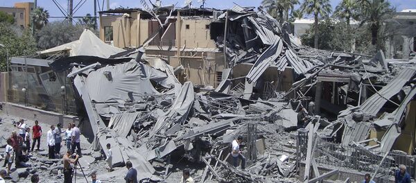 In this photo taken on a government-organized tour, media film damage from what officials said was a NATO airstrike at a hotel, in the capital Tripoli, Libya Thursday, June 16, 2011, while what officials described as a telecommunications tower is seen at left - Sputnik International