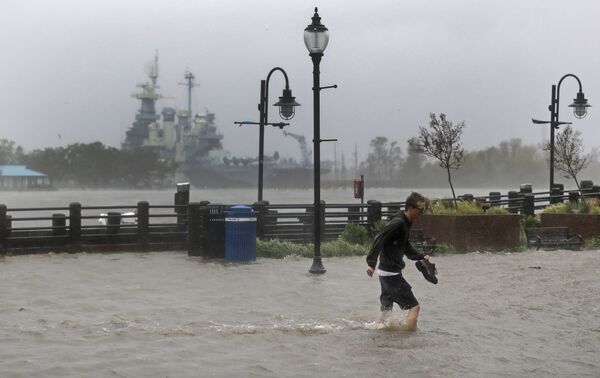 A man crosses a flooded street in downtown Wilmington, N.C., after Hurricane Florence made landfall Friday, Sept. 14, 2018. - Sputnik International
