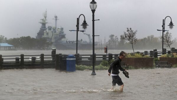 A man crosses a flooded street in downtown Wilmington, N.C., after Hurricane Florence made landfall Friday, Sept. 14, 2018. - Sputnik International