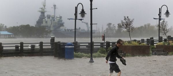 A man crosses a flooded street in downtown Wilmington, N.C., after Hurricane Florence made landfall Friday, Sept. 14, 2018. - Sputnik International