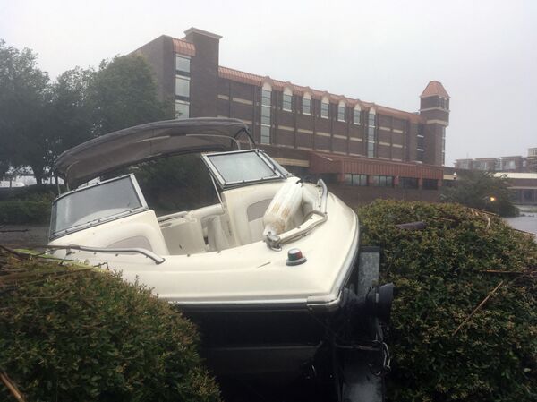 A speed boat sits wedged in bushes in the parking lot of a waterfront hotel in New Bern, N.C., on Friday, Sept. 14, 2018. Winds and rains from Hurricane Florence caused the Neuse River to swell, swamping the coastal city.  - Sputnik International