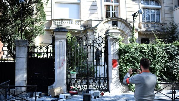 A French security officer takes a photograph outside the Iranian Embassy in the French capital Paris on September 14, 2018, after people taking part in a demonstration in a near by street split off and walked to the Iranian embassy where they sprayed red paint on the Embassy sign and trashed computers that were placed outside the embassy grounds for collection.  STEPHANE DE SAKUTIN / AFP - Sputnik International