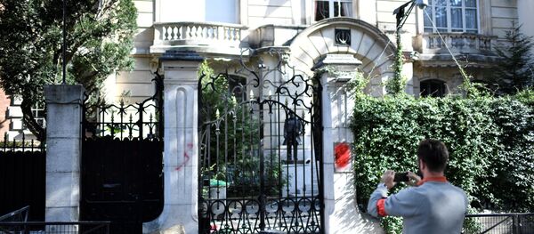 A French security officer takes a photograph outside the Iranian Embassy in the French capital Paris on September 14, 2018, after people taking part in a demonstration in a near by street split off and walked to the Iranian embassy where they sprayed red paint on the Embassy sign and trashed computers that were placed outside the embassy grounds for collection.  STEPHANE DE SAKUTIN / AFP - Sputnik International